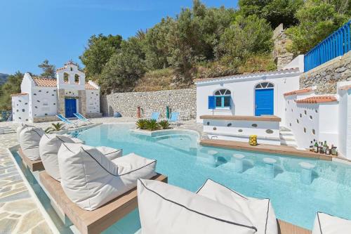 a villa with a swimming pool with lounge chairs at Sea View Kerame in Évdhilos