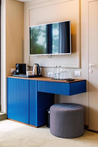 a blue counter with a tv above it in a room at Onal Boutique Hotelier in Mamaia
