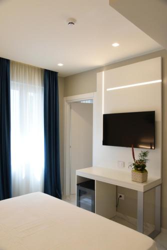 a bedroom with a bed and a desk with a tv at DEMSI Palace Hotel & Restaurant in Foggia