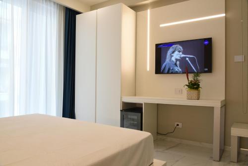 a hotel room with a bed and a tv on a wall at DEMSI Palace Hotel & Restaurant in Foggia