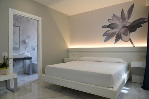 a bedroom with a bed with a flower on the wall at DEMSI Palace Hotel & Restaurant in Foggia