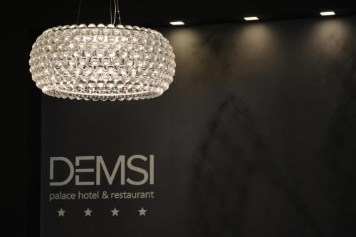 a chandelier hanging from a wall with the dennetts at DEMSI Palace Hotel & Restaurant in Foggia