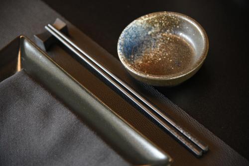 a bowl and chopsticks sitting on a black table at DEMSI Palace Hotel & Restaurant in Foggia