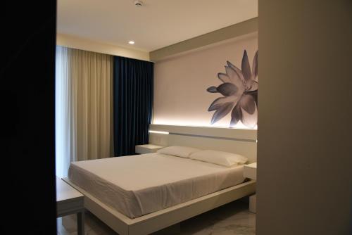 1 dormitorio con 1 cama y una pintura en la pared en DEMSI Palace Hotel & Restaurant, en Foggia