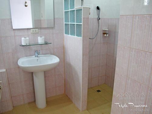 y baño de color rosa con lavabo y ducha. en Triple P Home Resort, en Pak Chong