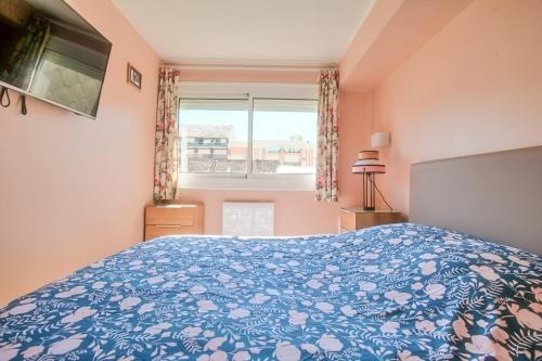 a bedroom with a blue bed and a window at La Douce Vie in Le Touquet-Paris-Plage