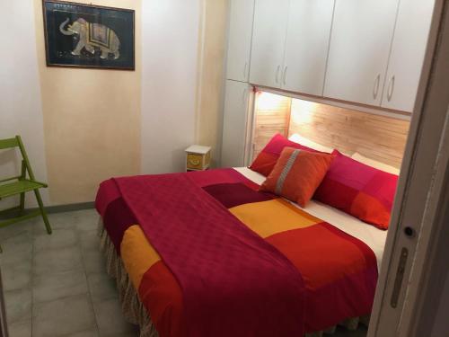 - une chambre avec un grand lit et des couvertures colorées dans l'établissement Casa Mirto, à Sassari