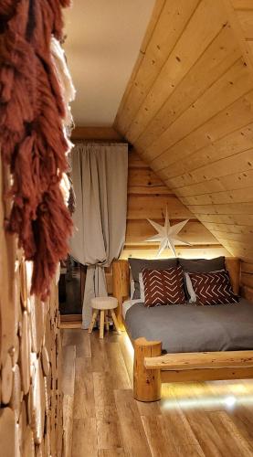 a bedroom with a bed in a log cabin at Chata Natura in Muszyna
