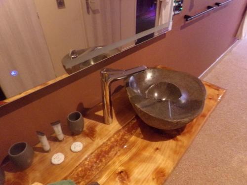a bathroom with a metal bowl on a wooden cutting board at chambre avec spa privatif in Loon-Plage