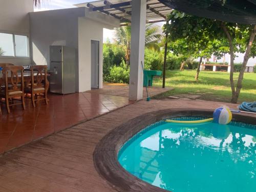 Una piscina en una casa con una mesa y sillas. en Casa Maria, en El Cebollito