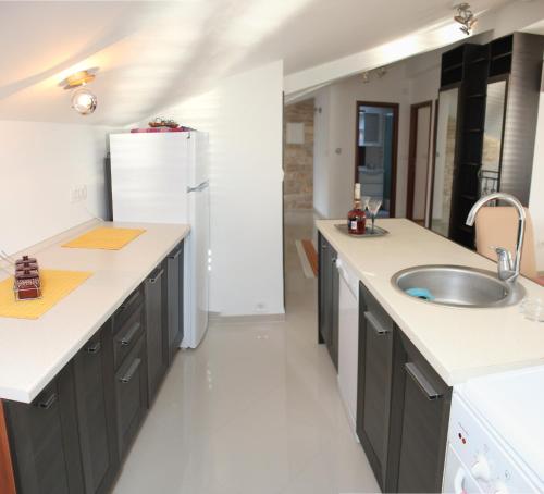 a kitchen with a sink and a refrigerator at Penthouse by the Sea in Tivat