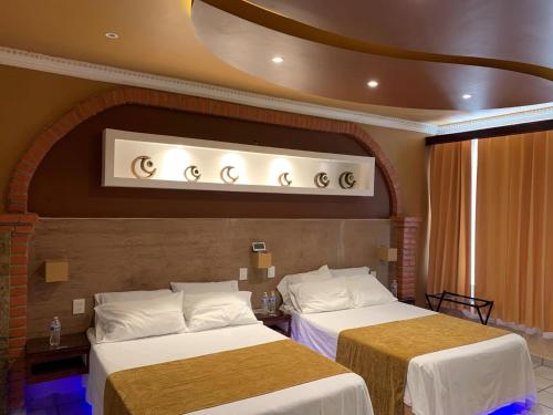 A bed or beds in a room at Hotel Boutique TEKALI INN