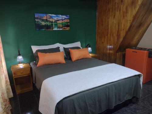 a bedroom with a large bed with orange pillows at Posada Portal del Iguazu in Puerto Iguazú