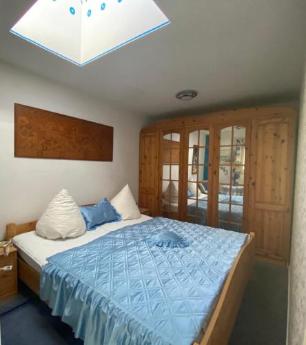 ein Schlafzimmer mit einem Bett mit blauer Bettdecke in der Unterkunft Himmlisch Wohnen in Bergen auf Rügen