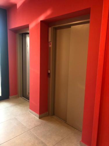 two elevator doors in a room with red walls at SWEET HOME Apartman , 30sqm studio, free private parking, mountain view, balcony, 20 min from downtown in Budapest