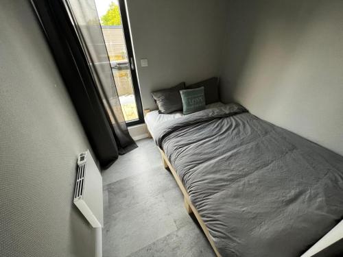 un piccolo letto in una camera con finestra di New houseboat 2 bedrooms a Zwartsluis