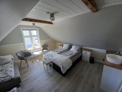 ein Schlafzimmer mit einem Bett und einem Waschbecken in einem Zimmer in der Unterkunft Pálshús in Patreksfjörður