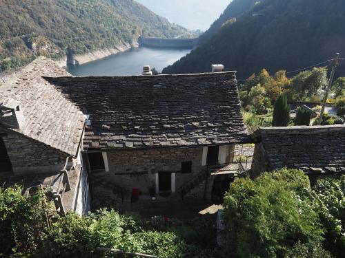 eine Gruppe von Häusern mit einem Fluss im Hintergrund in der Unterkunft Casa Bruja Tradizionale Rustico Ticinese in Mergoscia