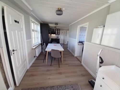 uma cozinha e sala de jantar com mesa e cadeiras em Pálshús em Patreksfjörður