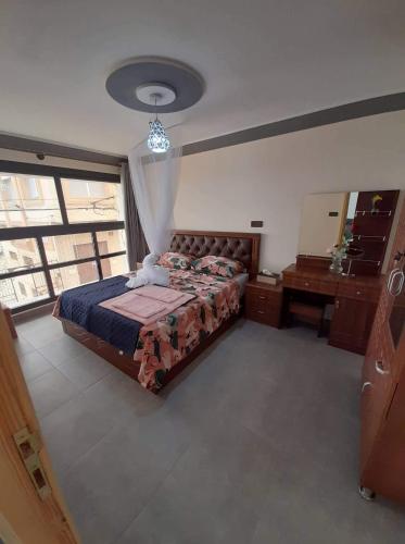 a bedroom with a bed and a desk and a mirror at Almarsa1 in Al Hoceïma
