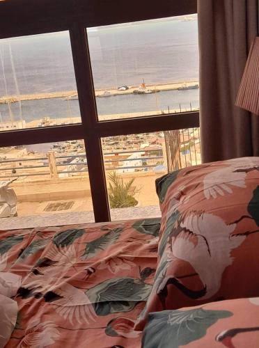 a bedroom with a view of the beach from a window at Almarsa1 in Al Hoceïma