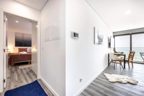 a room with white walls and a dining room with a table at Frontline Seaview Apartment in Budens