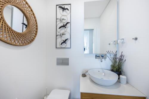 a bathroom with a sink and a mirror at Frontline Seaview Apartment in Budens