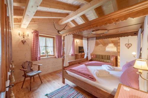 ein Schlafzimmer mit einem Bett und einem Stuhl in einem Zimmer in der Unterkunft Ötztal Chalet in Sautens