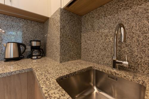 a kitchen with a sink and a coffee maker at Oasis Apartments in Jūrmala