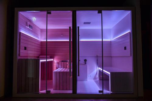 Habitación con puerta de cristal con luces moradas en Sempione Boutique Hotel, en Stresa