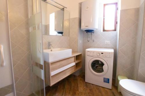 a bathroom with a washing machine and a sink at Il tulipano della Valle Soana in Ronco Canavese