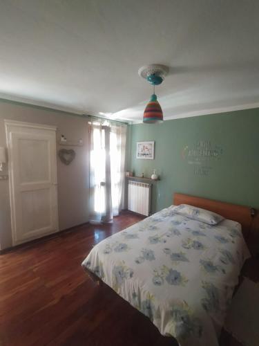 Schlafzimmer mit einem Bett, einem Fenster und einer Tür in der Unterkunft La Casa di Vitto in Boves