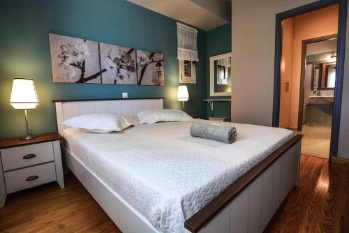 a bedroom with a large white bed with two lamps at Aigli Luxurious Villa in Káto Pitsá