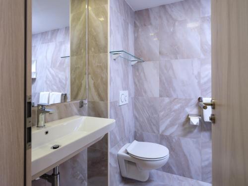een badkamer met een wit toilet en een wastafel bij B&B Boutique Eluize in Dubrovnik
