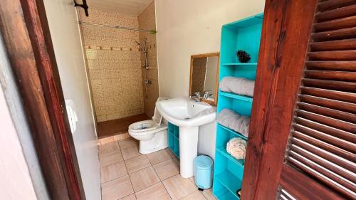 y baño con aseo y lavamanos. en Matatia Lodge, en Punaauia