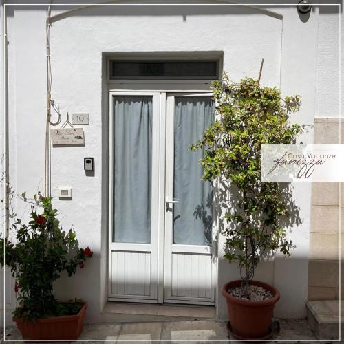 einer Haustür eines Hauses mit zwei Topfpflanzen in der Unterkunft Sofia Stone House in Alberobello