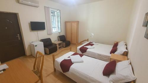 una camera d'albergo con due letti e una televisione di Kesabella Touristic House a Yerevan