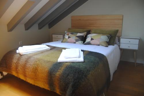 1 dormitorio con 1 cama con toallas en El RINCÓN DE OJEDO -POTES- PICOS DE EUROPA-, en Ojedo