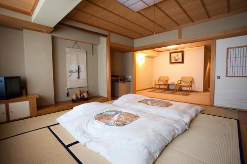 a large white bed in a room with a tv at Shiga Kogen Hotel Shiga Sunvalley in Yamanouchi