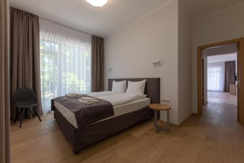 a bedroom with a bed and a large window at Oasis Apartments in Jūrmala