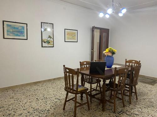 a dining room with a table with a laptop on it at Casa vacanze ferro in Trapani