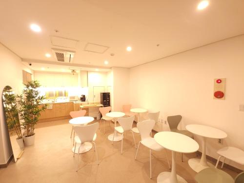 een kamer met tafels en stoelen en een keuken bij OYO Hostel Myeongdong 2 in Seoul