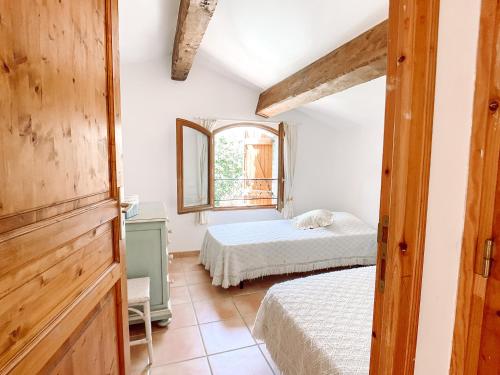 une chambre avec deux lits et une fenêtre dans l'établissement Maisonnette dans la colline,port d'Alon & calanque, à Saint-Cyr-sur-Mer