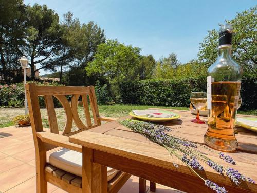 - une table en bois avec une bouteille d'alcool dans l'établissement Maisonnette dans la colline,port d'Alon & calanque, à Saint-Cyr-sur-Mer