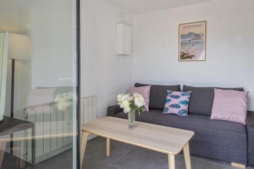 un salon avec un canapé et une table dans l'établissement Superbe appartement avec terrasse et parking - Saint-Jean-de-Luz - Welkeys, à Saint-Jean-de-Luz
