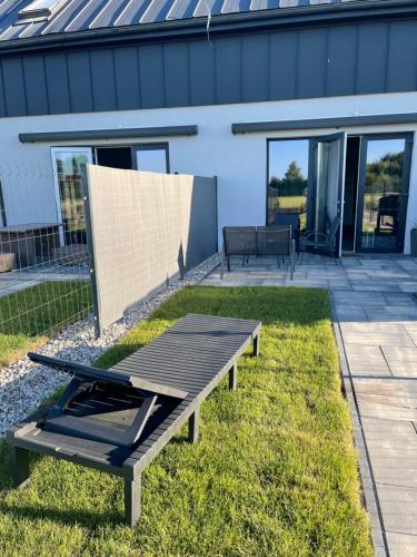 a picnic table on a lawn in front of a house at Koniec Świata Stare Sady apartament in Mikołajki