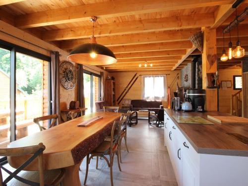 une cuisine et une salle à manger avec une grande table en bois dans l'établissement Le Mont-Dore: Splendide Chalet 5 Chambres avec Terrasse, Garage Double, et WiFi - FR-1-608-188, à Le Mont-Dore