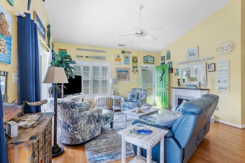 a living room with a blue couch and chairs at On Island Time in Atlantic Beach