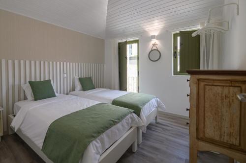 a bedroom with two beds and a mirror at Casa da Torre in Amarante