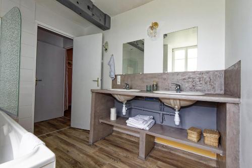 un bagno con due lavandini e un grande specchio di LE MOULIN DU COUFFON a Kerlouan